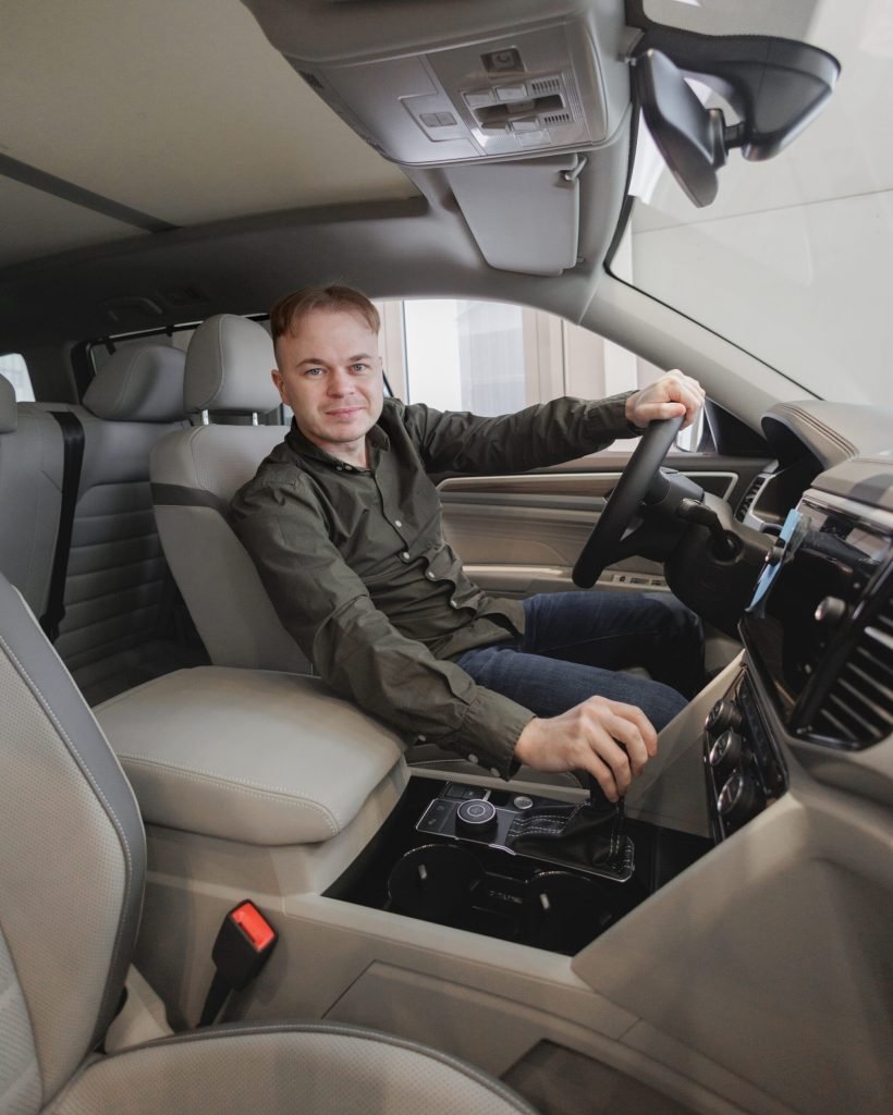 happy-man-is-sitting-in-car-in-a-car-dealership-2023-11-27-05-01-24-utc